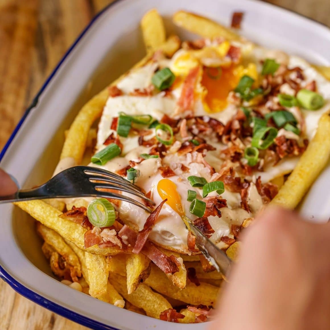 Loaded fries cu ou ochi, bacon și ceapă verde de la Switch.Eat – comfort food perfect pentru pauza de prânz și parte din snack culture în București.