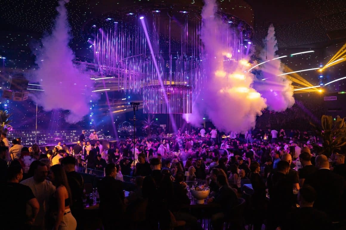 Imagine de ansamblu din Face Club, cu lumini difuze, candelabre imense si oameni care danseaza