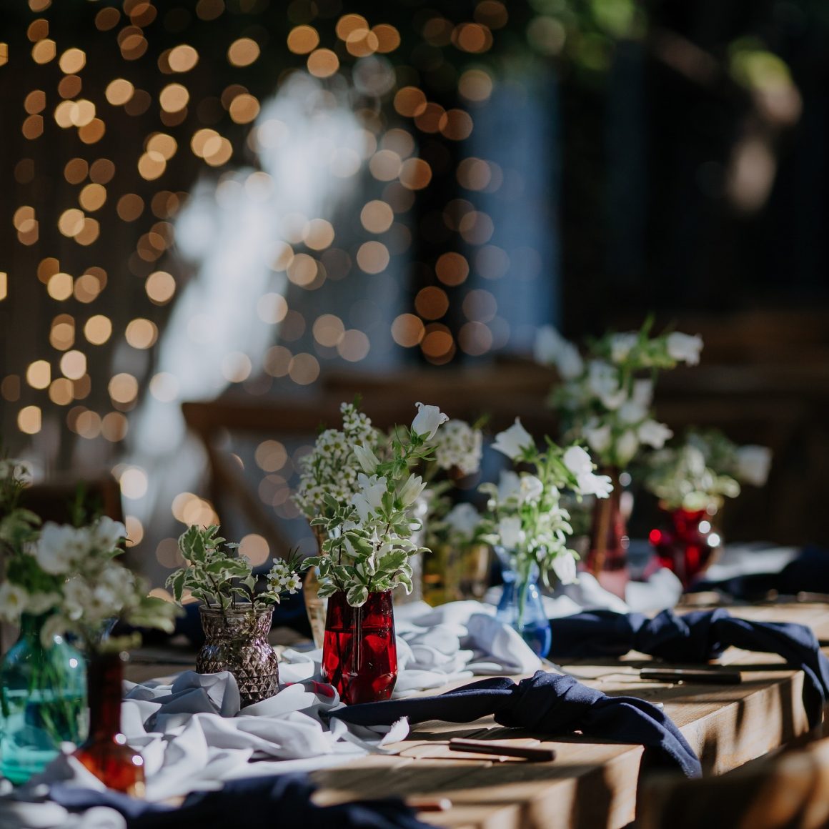 masa docarată vestiv, elegant, cu flori si luminite de craciun in fundal