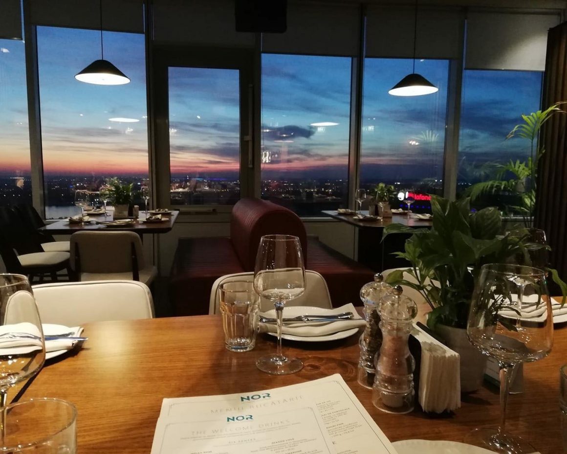 imagine de ansamblu din restaurantul NOR Sky Casual, cu vedere catre ferestrele cu vedere panoramica asupra Bucureștiului noaptea