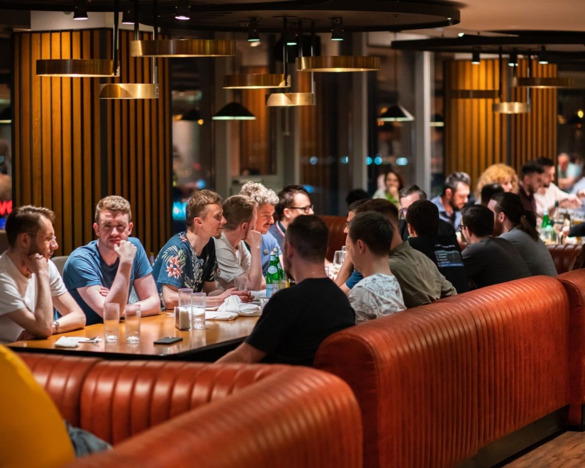 Masa intinsa de oameni care iau cina in restaurantul NOR din București, potrivit pentru petrecerea de Crăciun a firmei sau petreceri corporate