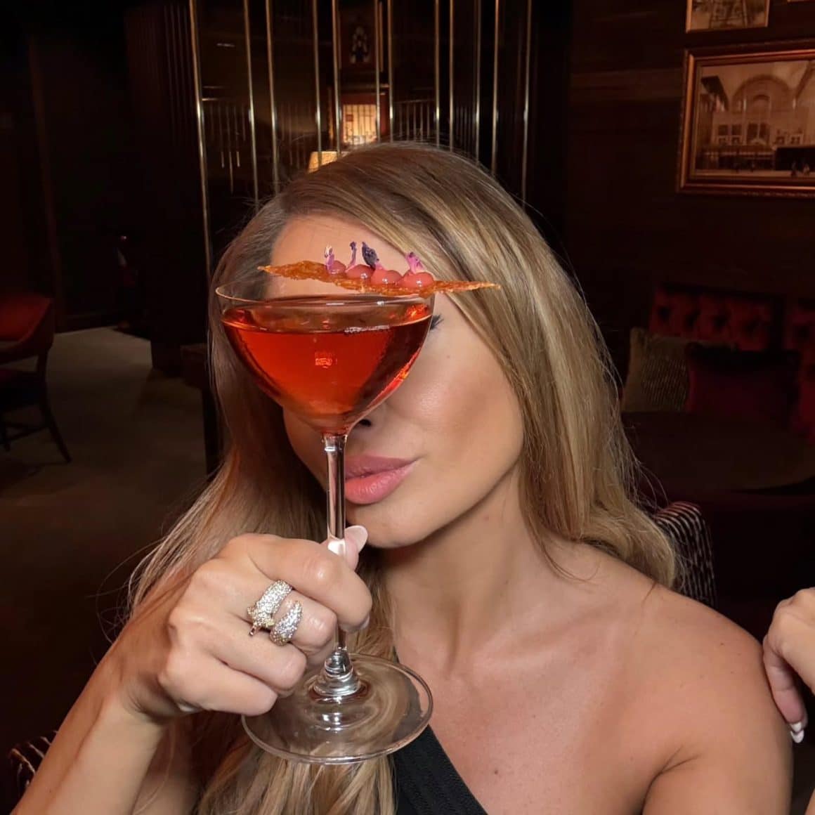 Femeie tine in mana un pahar de Sober Manhattan, mocktail fără alcool. Cocktail Bar București.