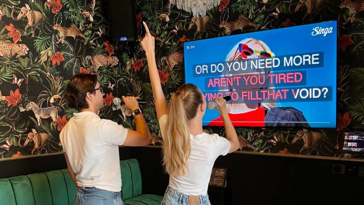 Cuplu canta urmarind versurile de un televizor, intr-o cameră privată de karaoke în București, la Kao Chinese Restaurant and private karaoke rooms