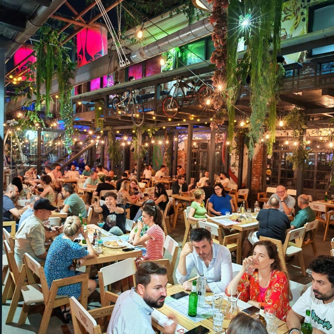 Mai multi oameni iau masa pe terasa de la Fabraica Bucuresti