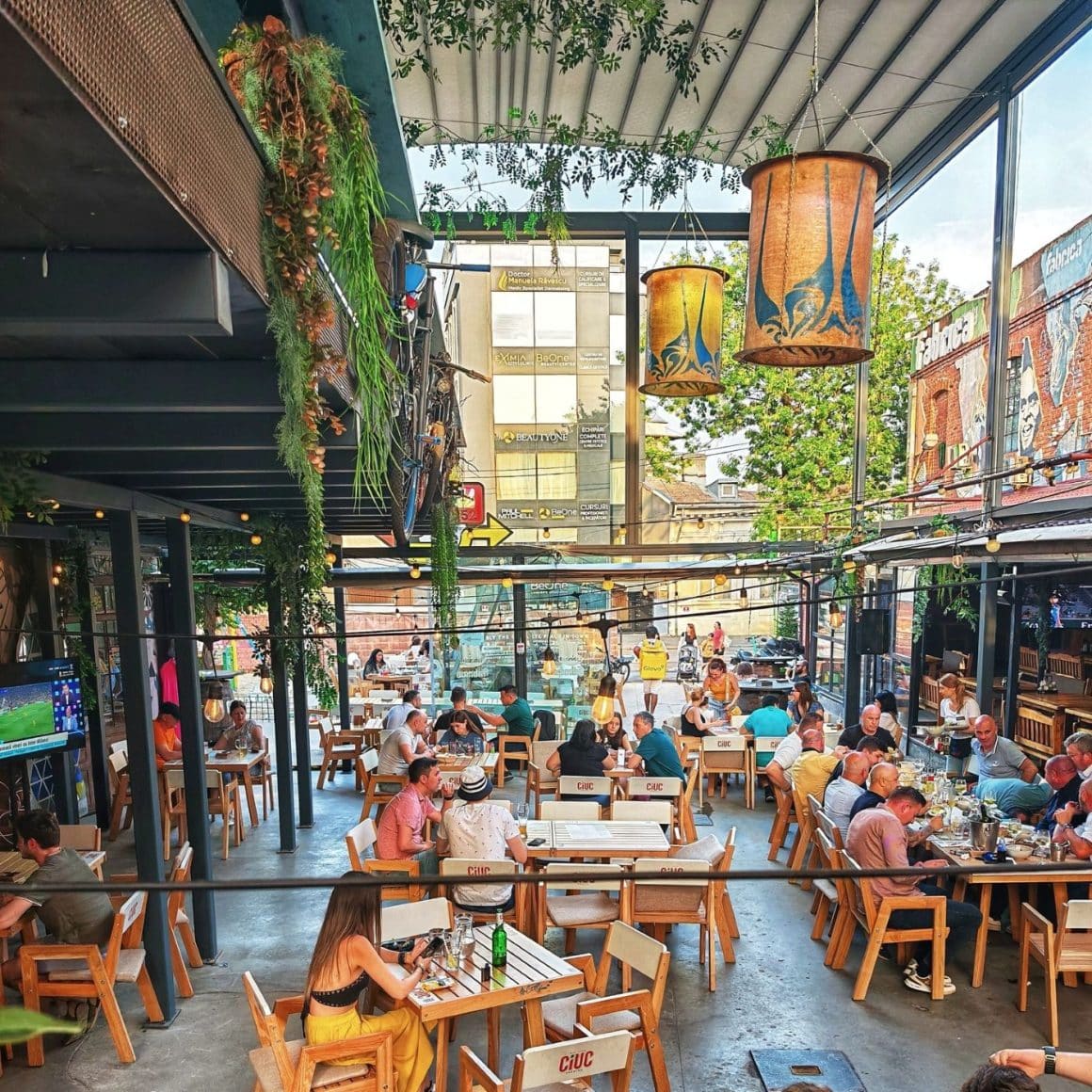 Mai multi oameni iau masa pe terasa de la Fabraica Bucuresti
