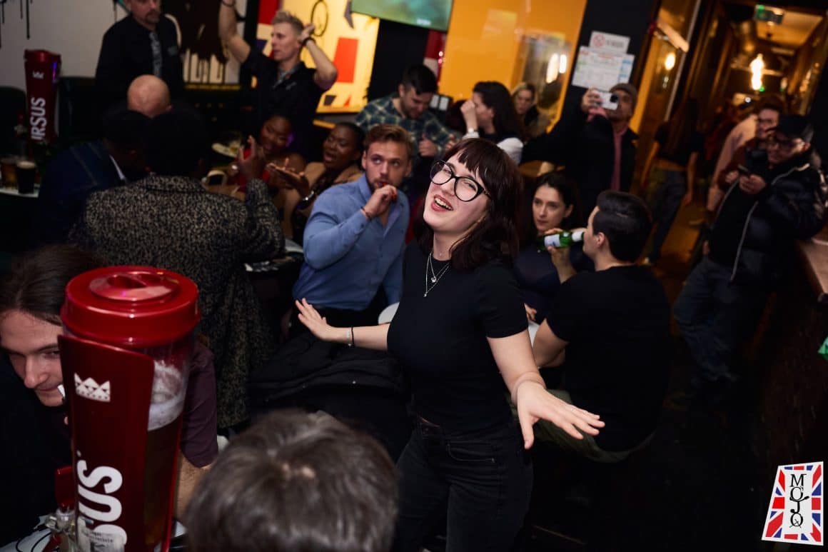 Tineri se distreaza la o seara de karaoke în București