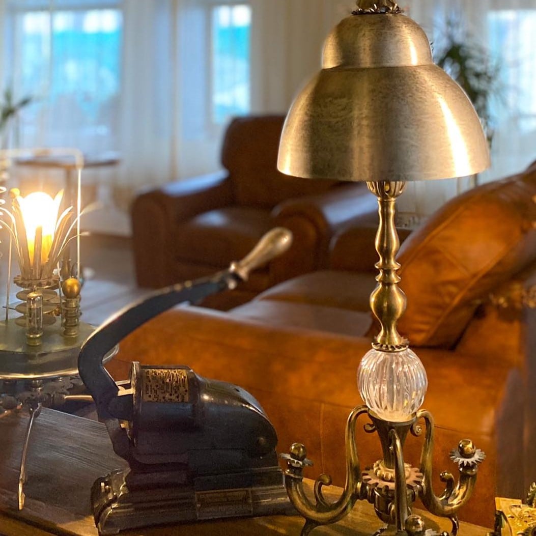 Detaliu de decor din lobby-ul Casa Hrisicos – lampă vintage de alamă și obiecte de colecție din epoca 1900