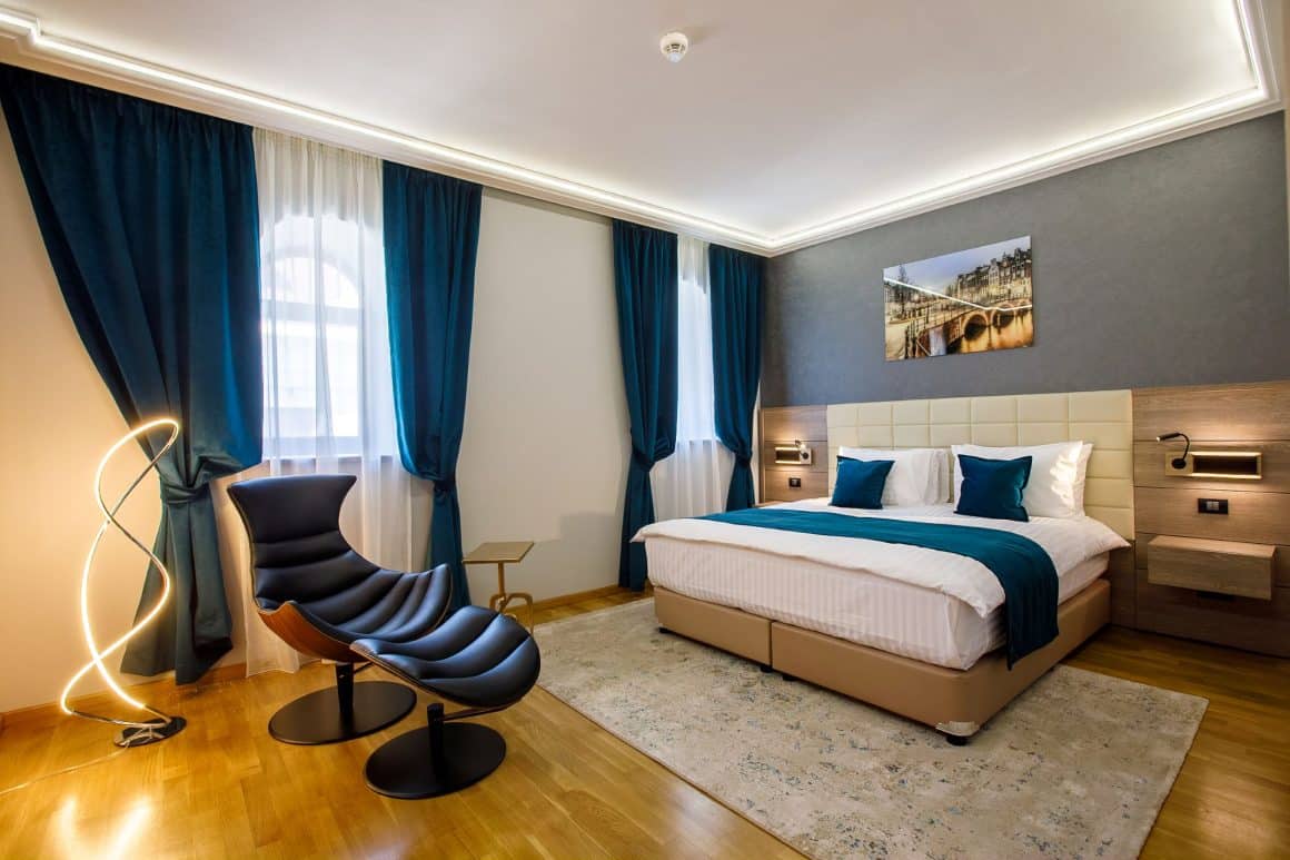 Cameră deluxe cu pat king size și fotoliu de design la hotelul boutique din centrul vechi al Constanței