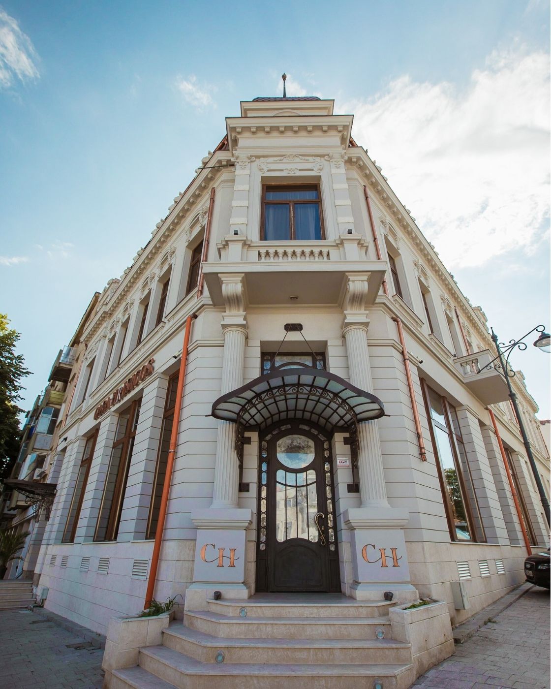 Hotel Casa Hrisicos Constanța – intrarea principală cu copertină Art Nouveau și fațada renovată a clădirii de patrimoniu