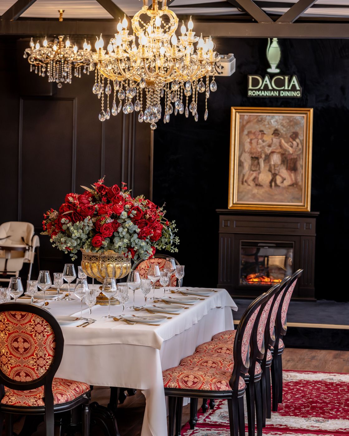 Sala de dining Dacia Romanian Dining Buzău, cu candelabru și tablouri cu portrete regale