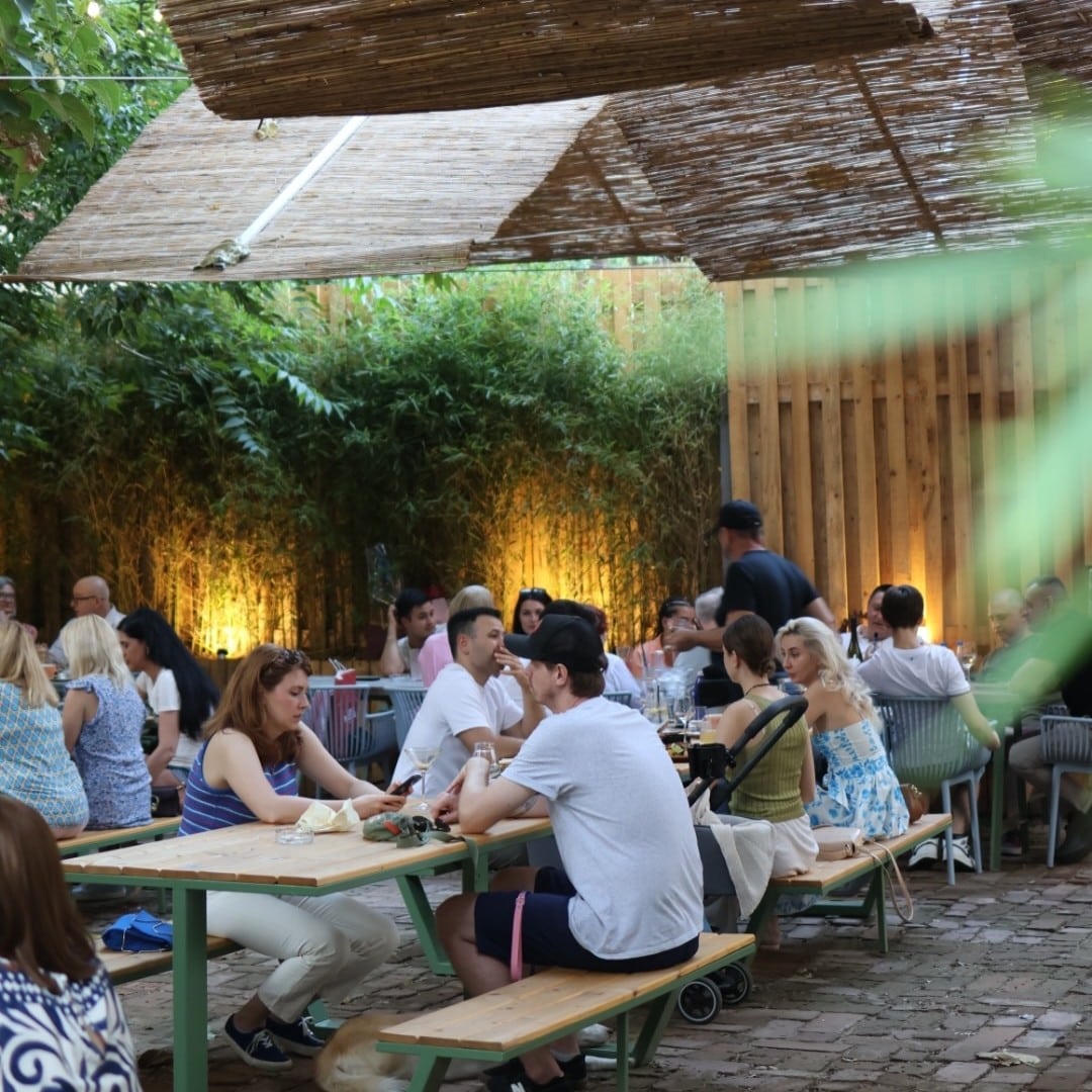 Grădina din spate Bruma Coffee & Wine, plină de oameni, printre locuri noi în București