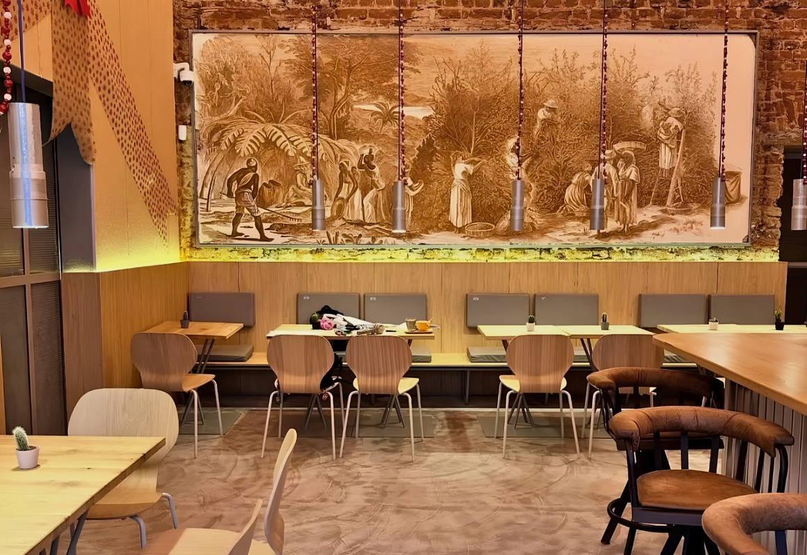 Locuri noi în București: sala Bruma Coffee & Wine, cu banchete din lemn și mural cu recoltarea cafelei