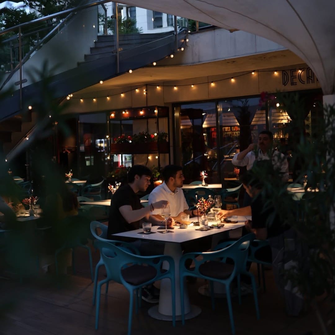 Prieteni iau cina seara pe terasa Decadance si beau un pahar de aperitivo