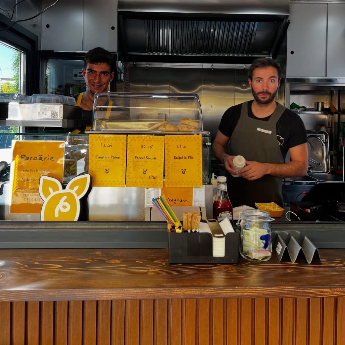 Proprietarii de la Porcărie București, servesc sandvisuri clientilor