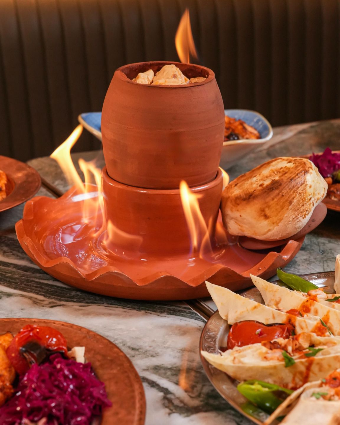 Preparat turcesc servit flambat, cu pâine și garnituri la Beyti restaurant