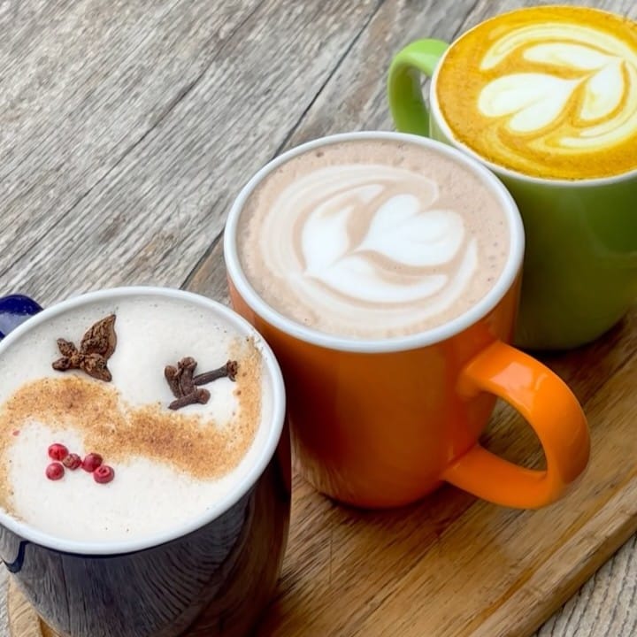 Latte-uri de sezon la Boiler Coffee, București: Masala Latte cu scorțișoară și condimente, alături de Turmeric Latte, cremos, cu nuanțe aurii și latte art.