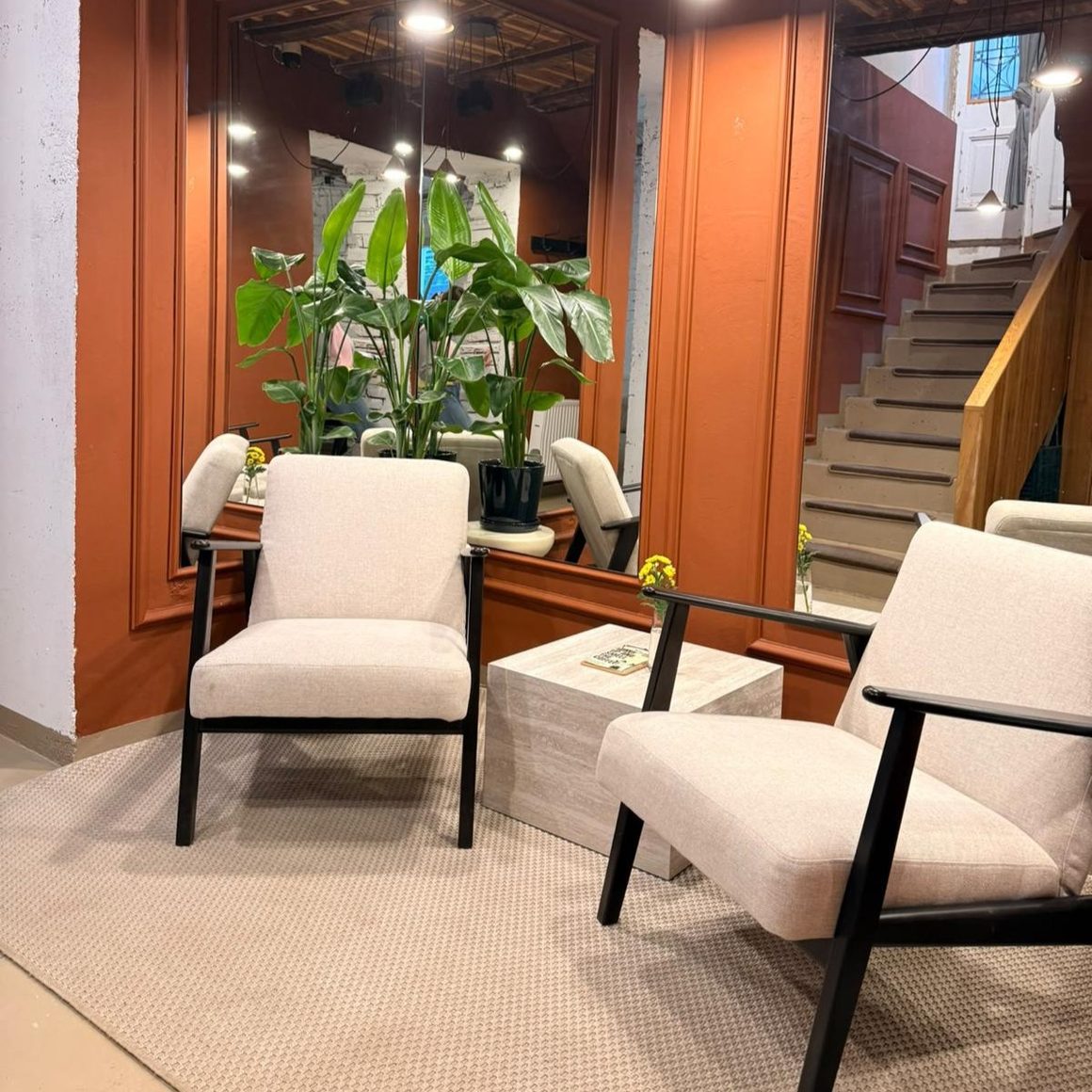 Cremma Café, București, cu zonă de relaxare amenajată în tonuri calde, fotolii confortabile și plante decorative.