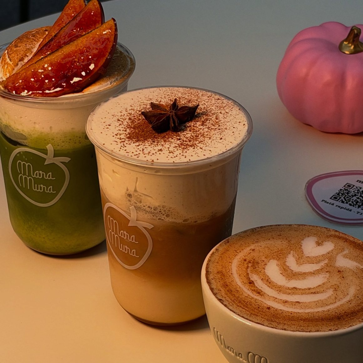 Pumpkin latte și matcha de sezon la Mara Mura, cu toppinguri decorative și arome de toamnă, alături de o cafea cu latte art.