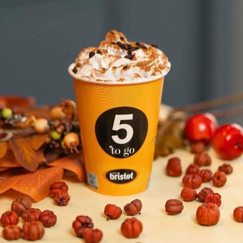 Pumpkin Spice Latte la 5 to go, cu frișcă, topping de Oreo și decor de toamnă în nuanțe arămii.